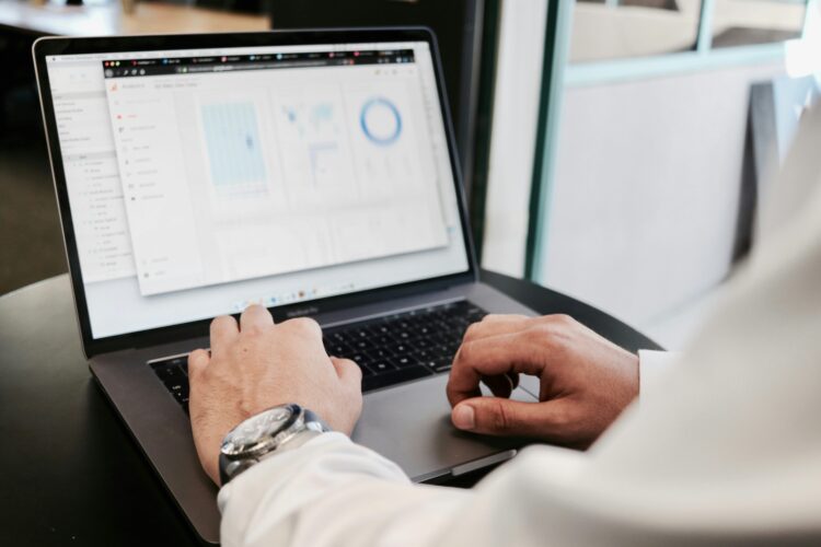 A business professional reviewing visualized marketing data on a laptop screen in a modern office setting.