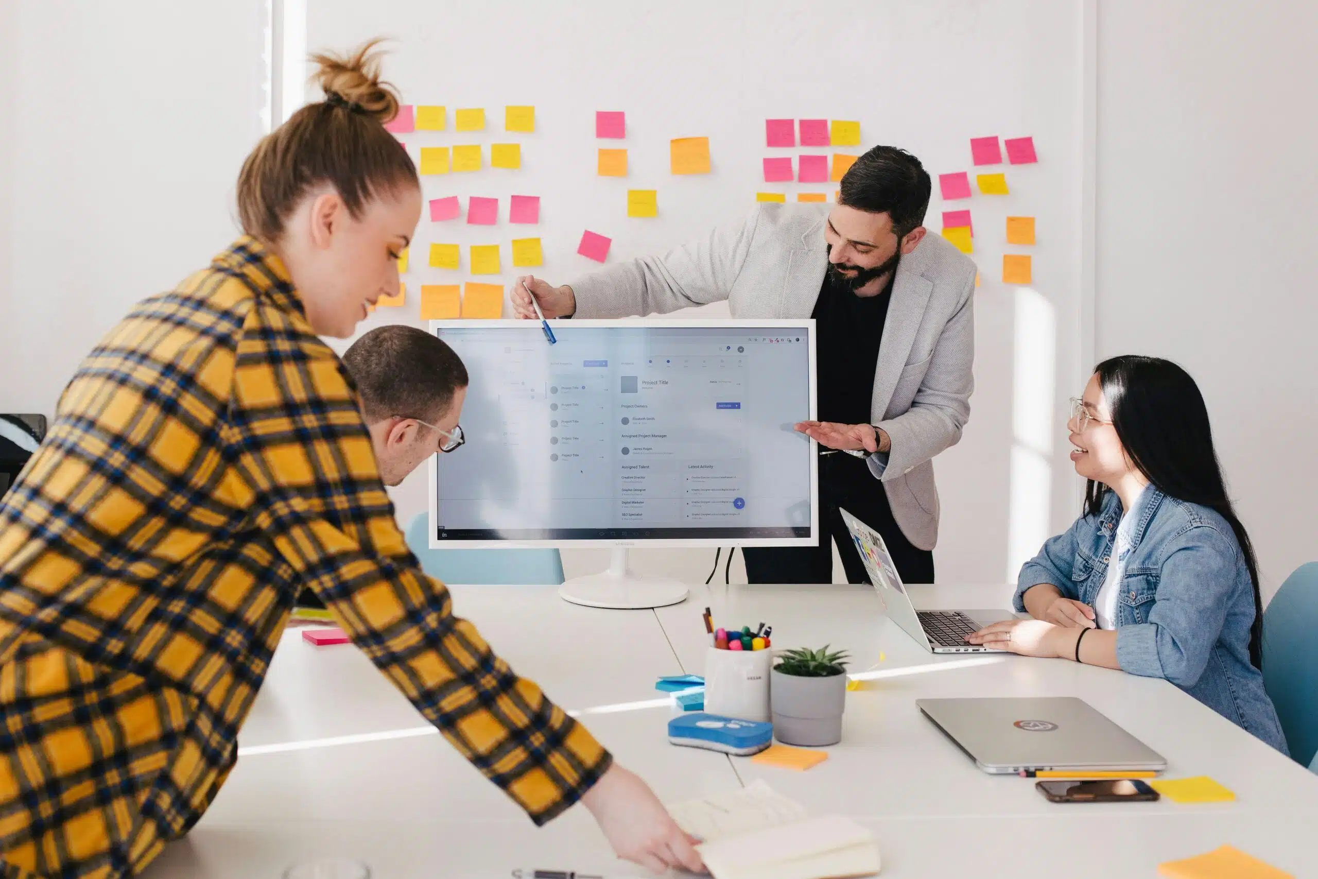 Marketing team reviewing AI campaign data on a screen with sticky notes in the background