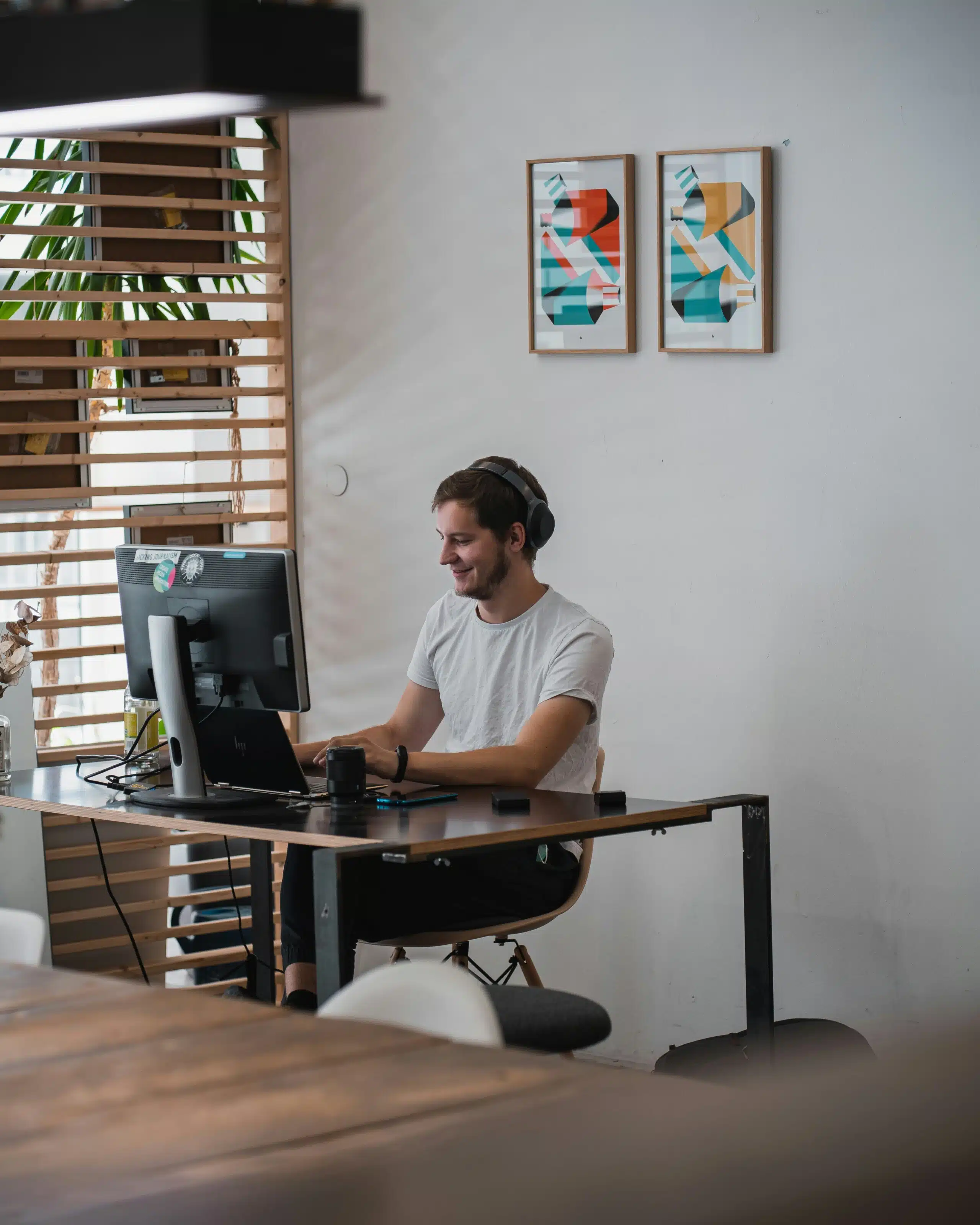 A man wearing headphones working at a computer in a modern workspace, symbolizing the evolving role of AI chatbots in future lead generation workflows.