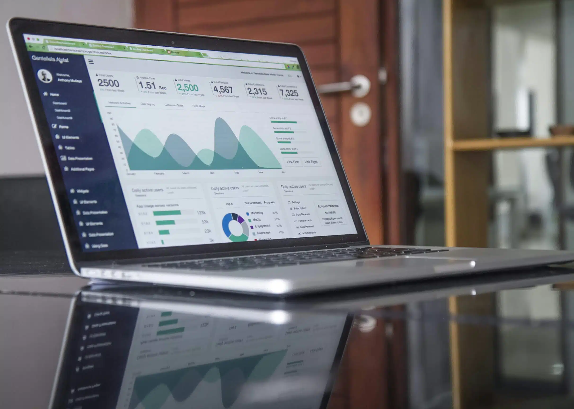 A laptop displaying SEO analytics on a reflective surface in a modern workspace.
