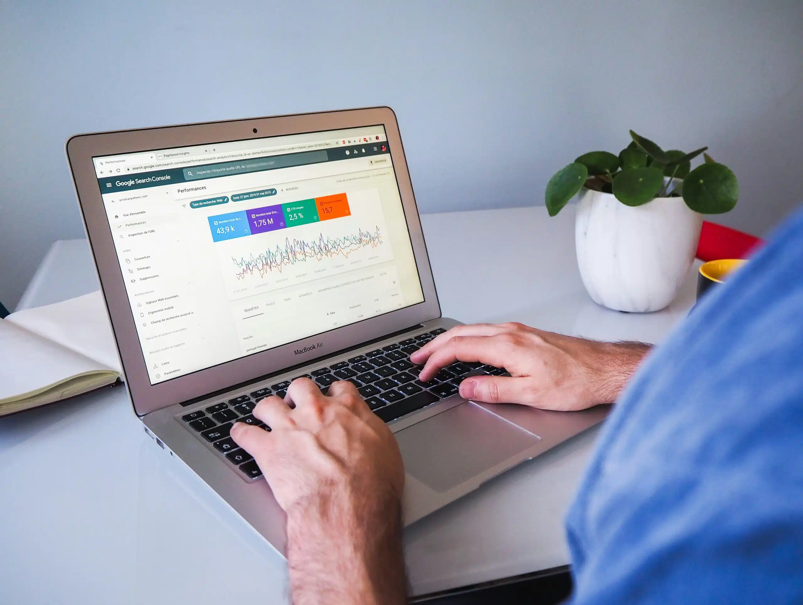 Hands typing on a laptop showing Google Search Console traffic data and trends.