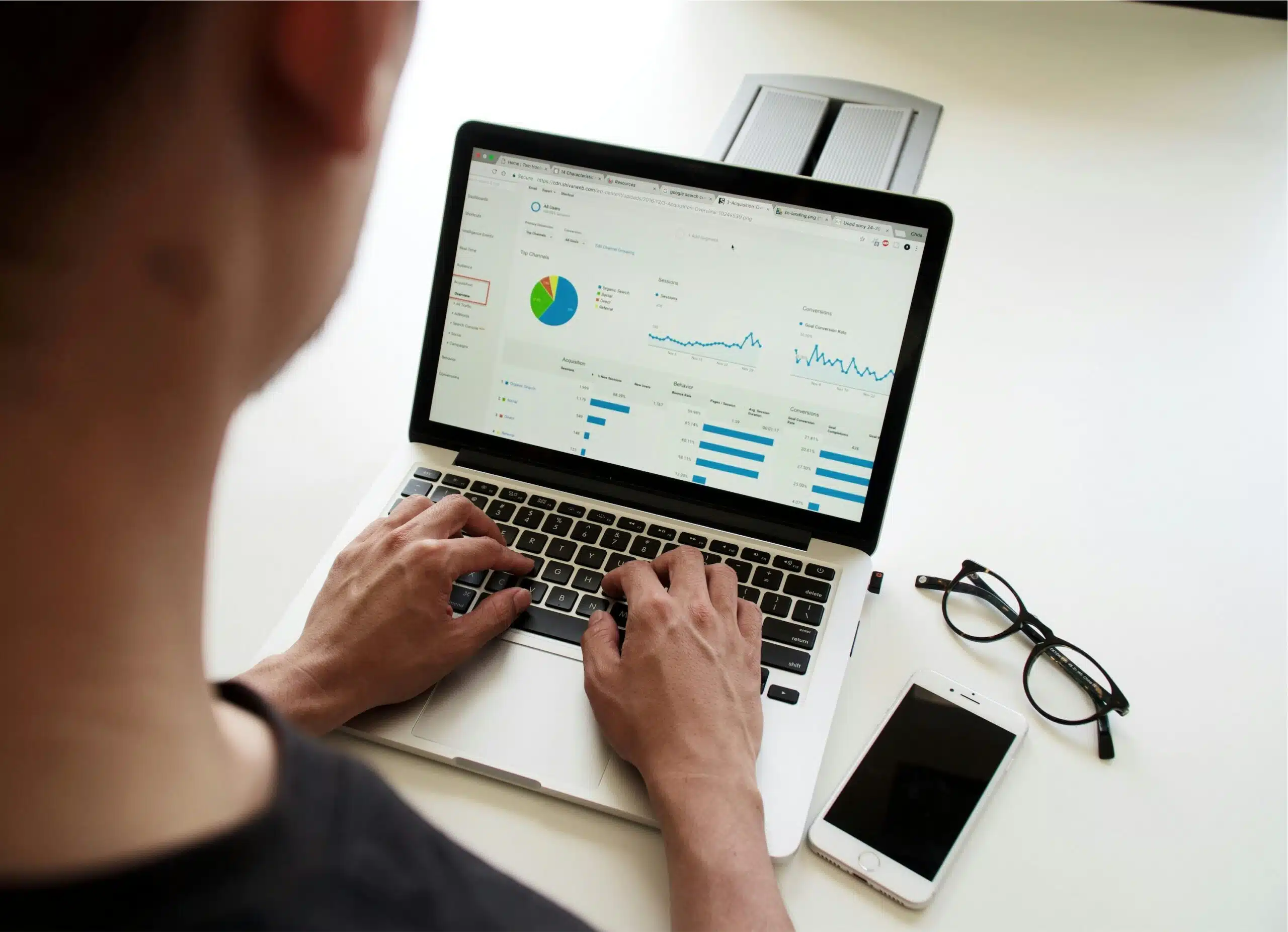 A person working on a laptop with an analytics dashboard open, illustrating the importance of testing AI SEO tools before committing.