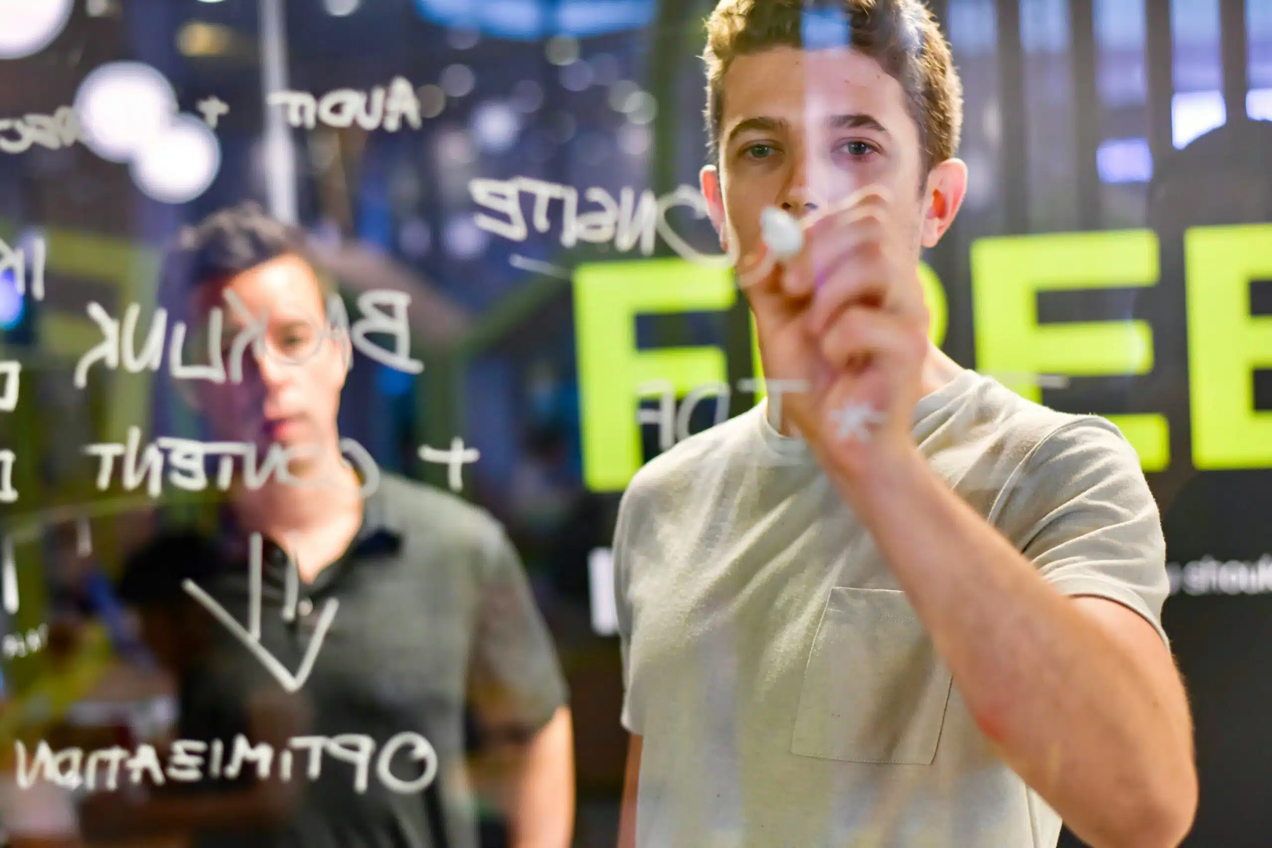 Marketing team brainstorming SEO optimization strategies on glass board