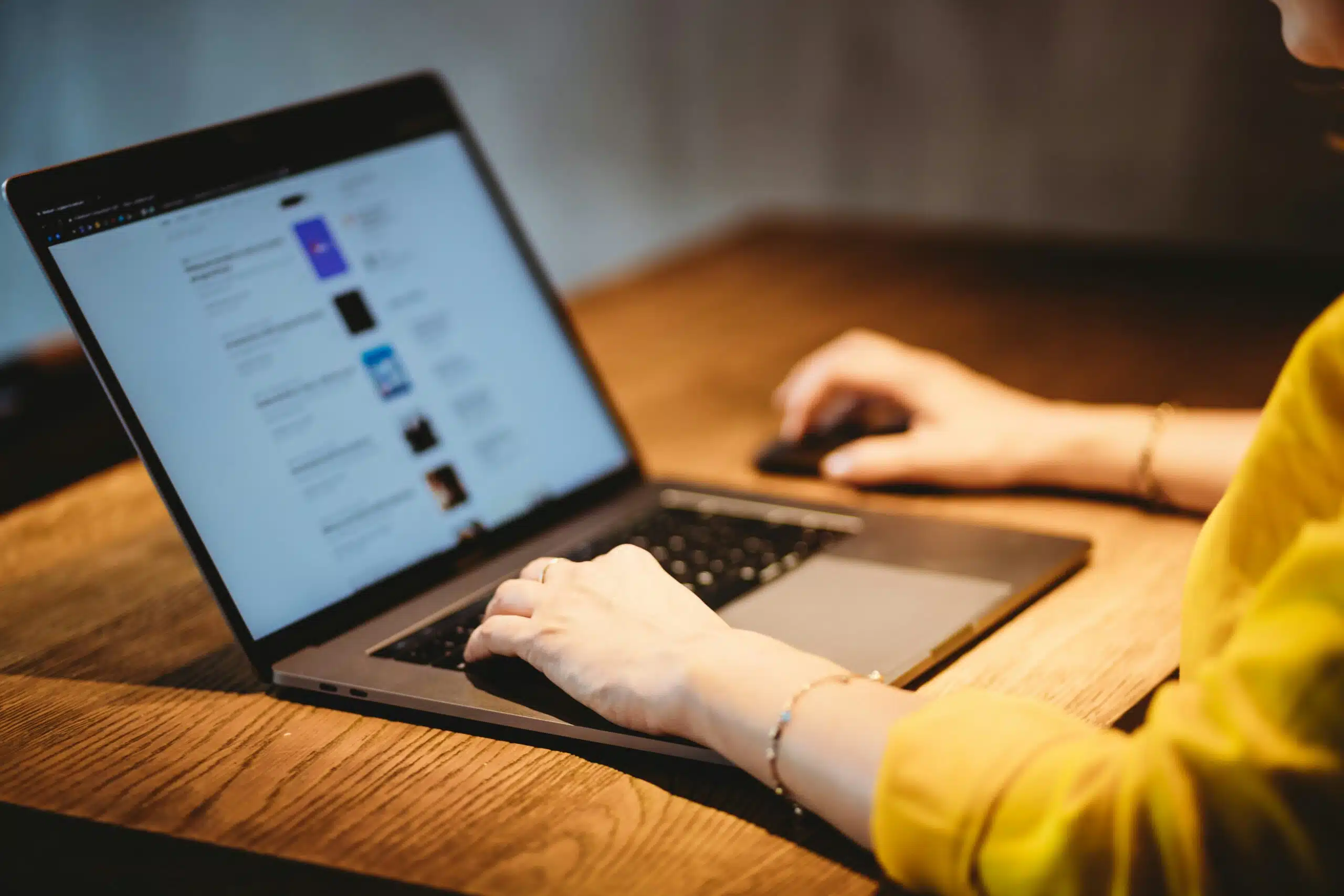 Person working SEO content generation tool on a laptop in a dimly lit setting