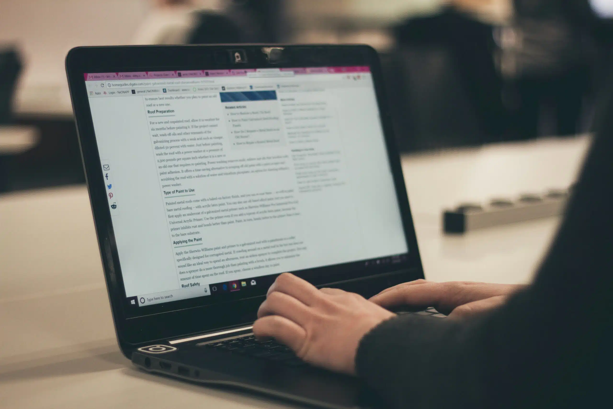 Hands typing on a laptop with an article on the screen, representing AI-driven content strategy.