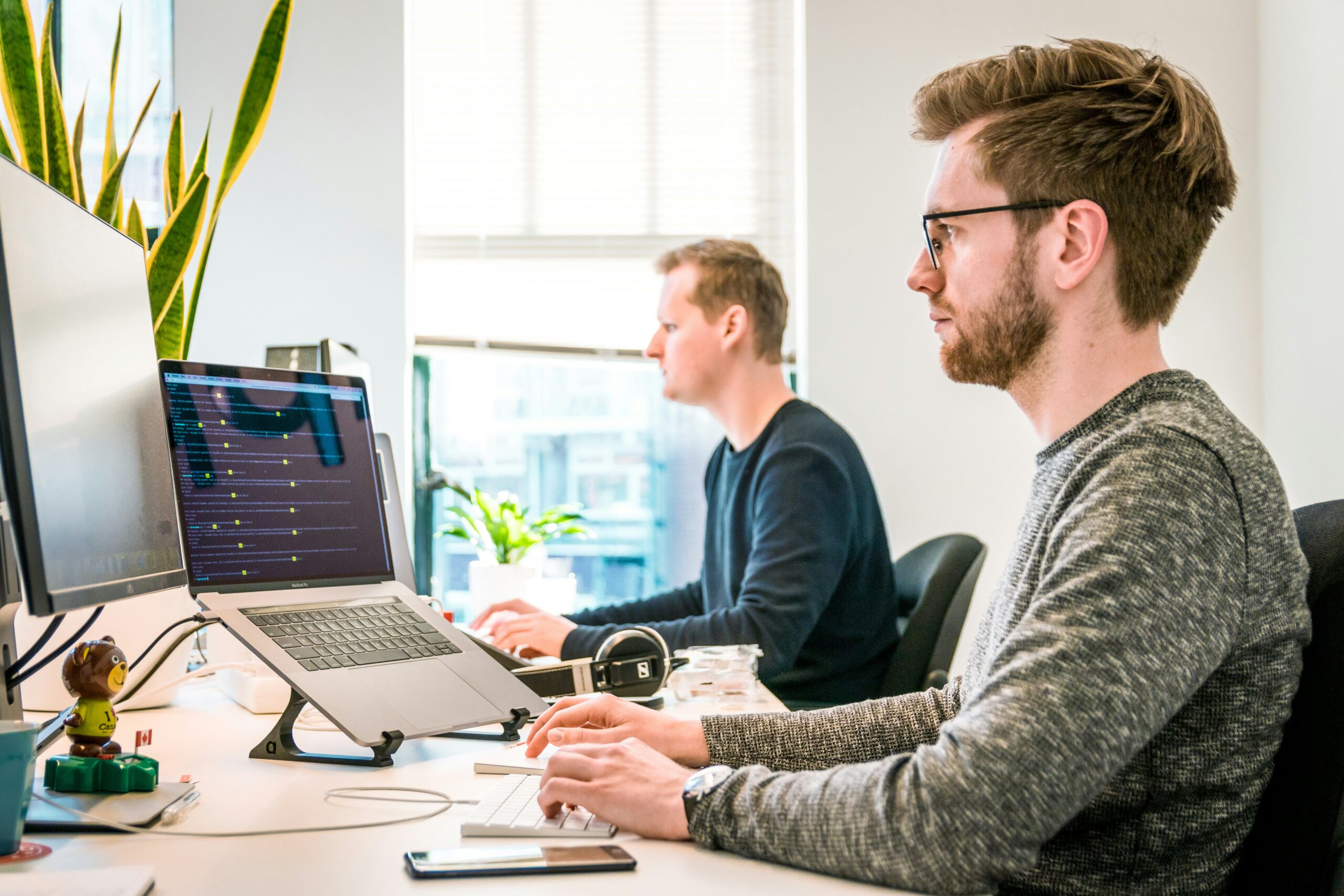 two men working on computers in an office