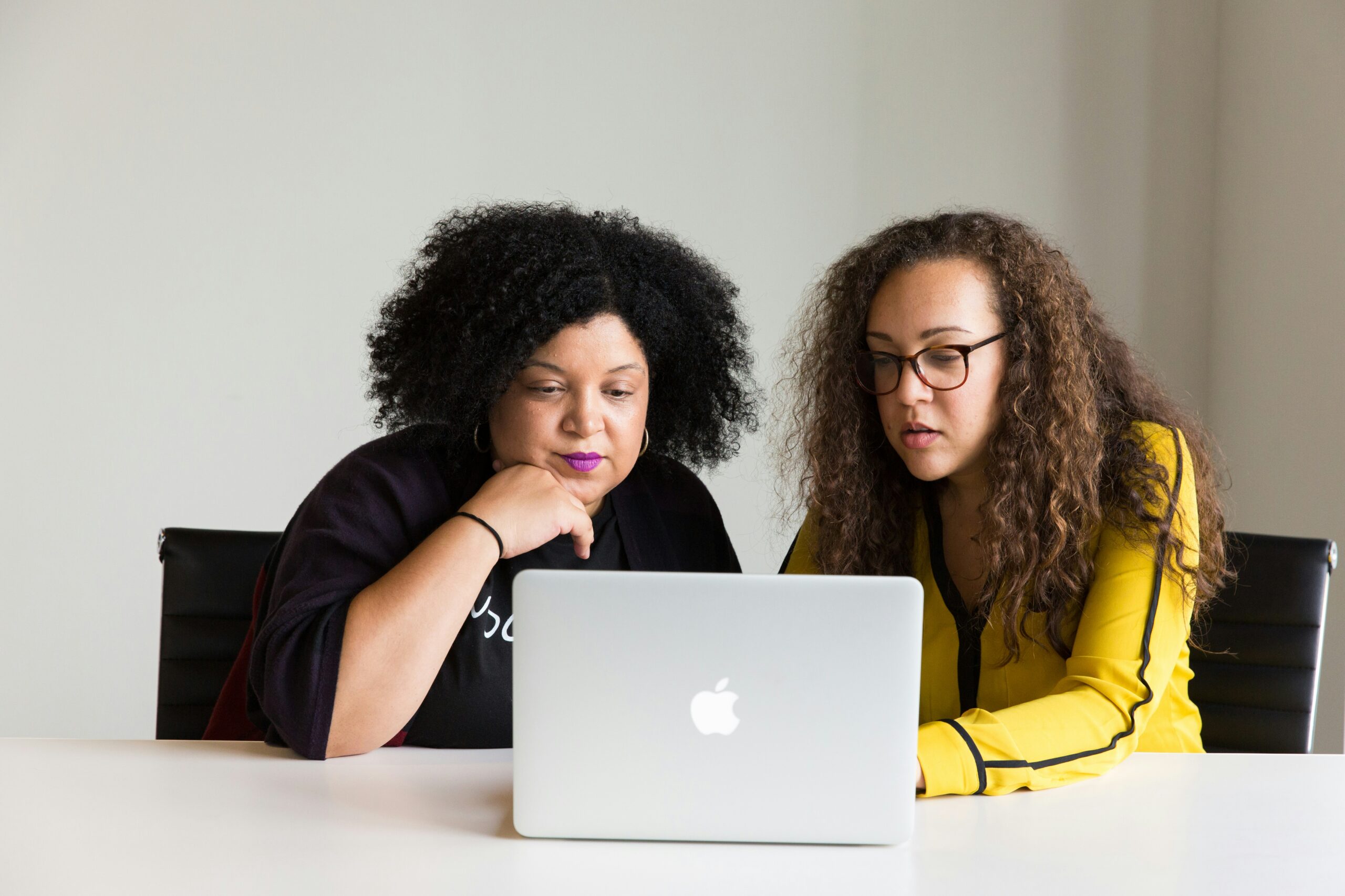 two women using laptop