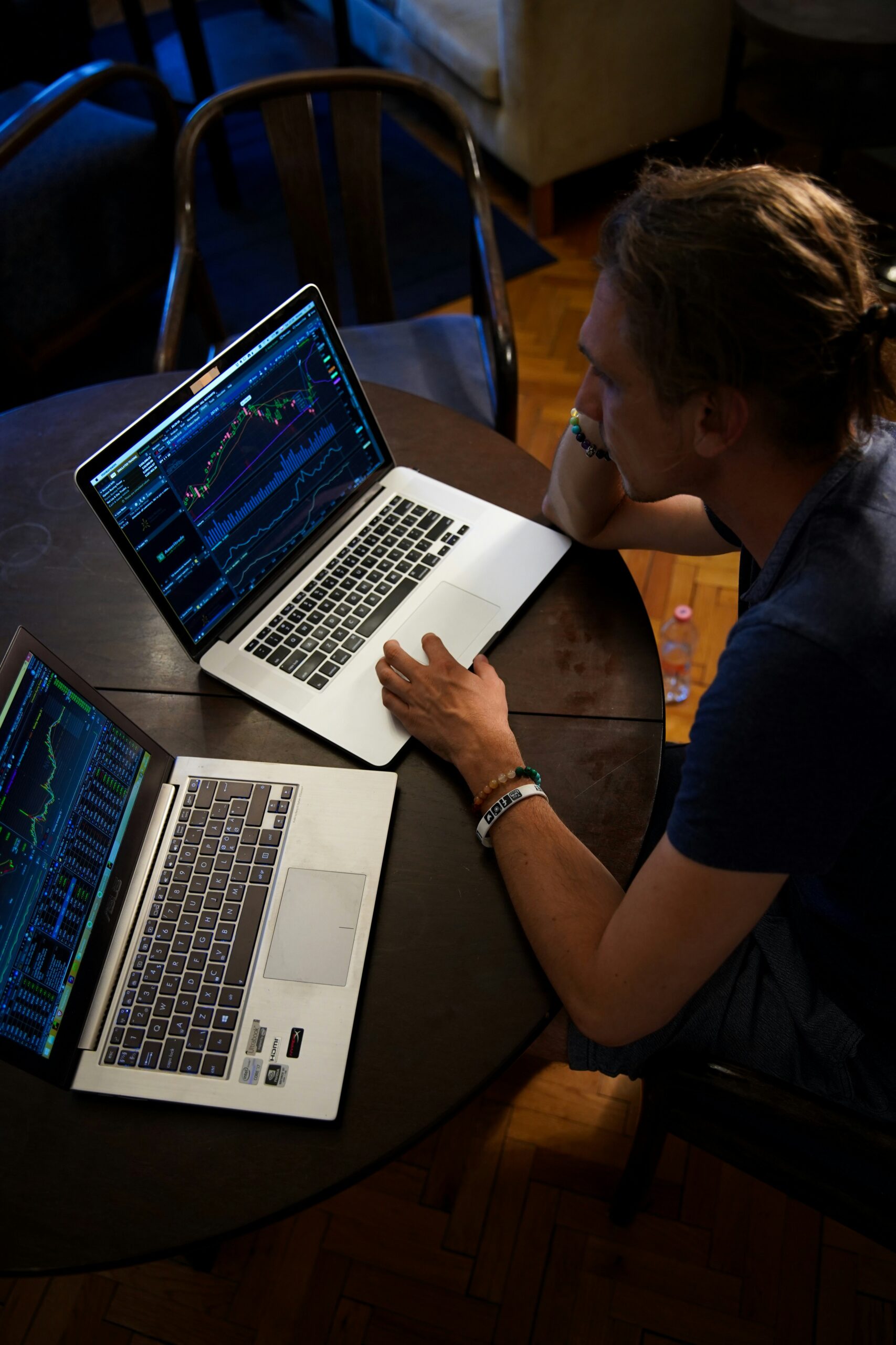  A person analyzing marketing data on two laptop screens, displaying graphs and charts.