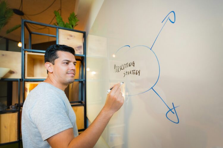 a marketer writing "marketing strategy" on white board