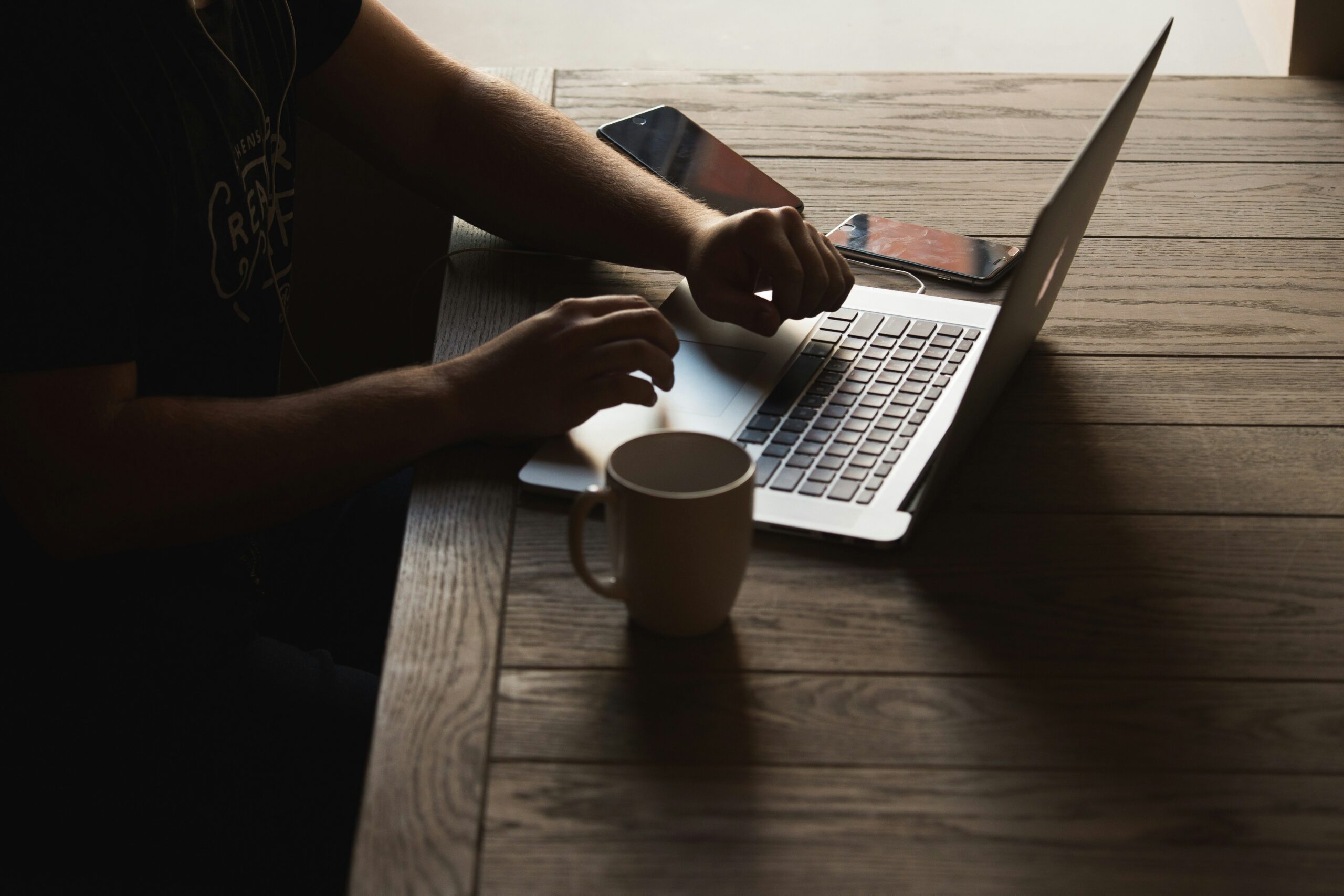 A business professional working on a laptop in a dimly lit space