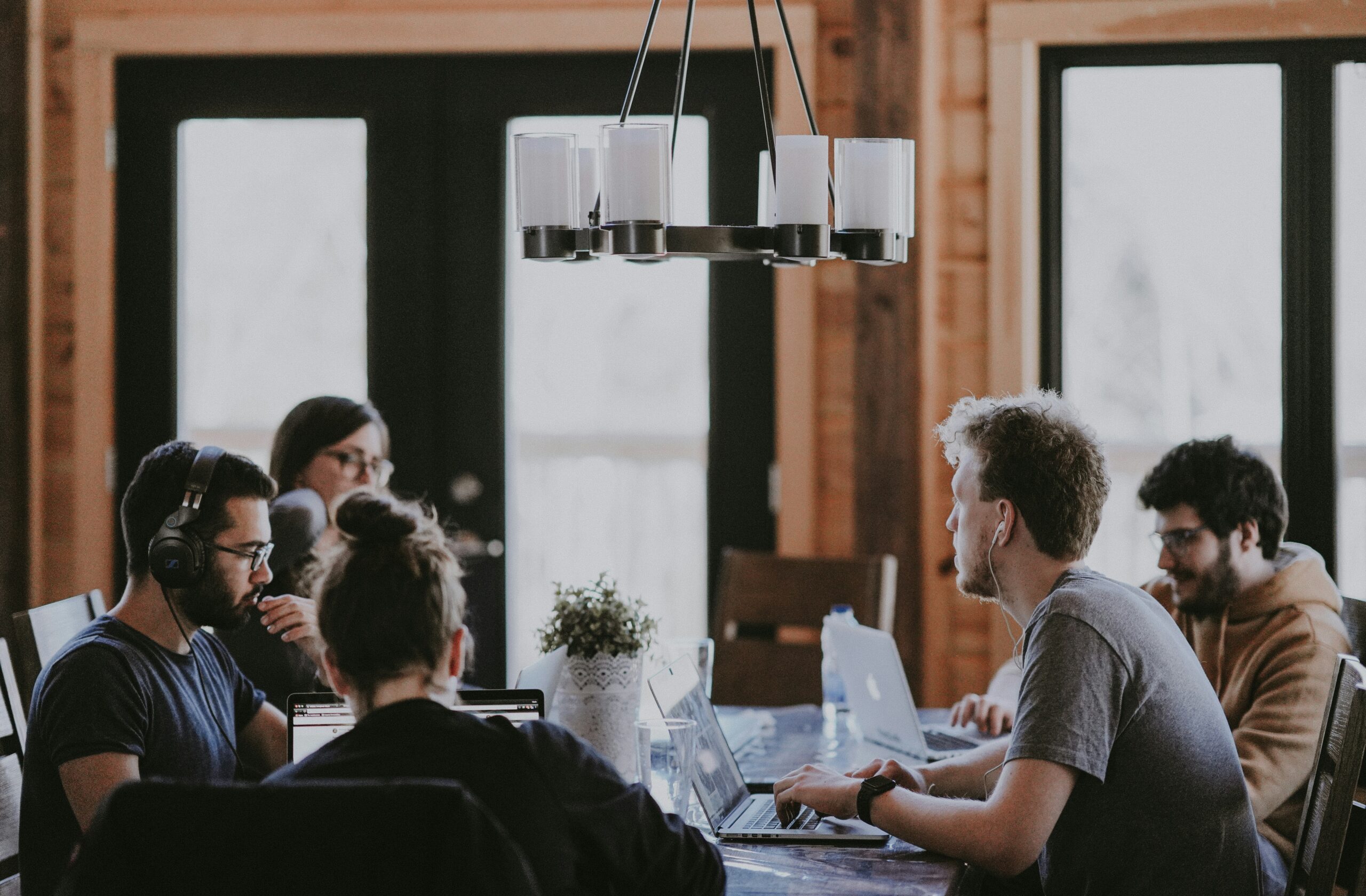 A group of marketers collaborating in a workspace, utilizing AI-powered data analysis tools for market research.