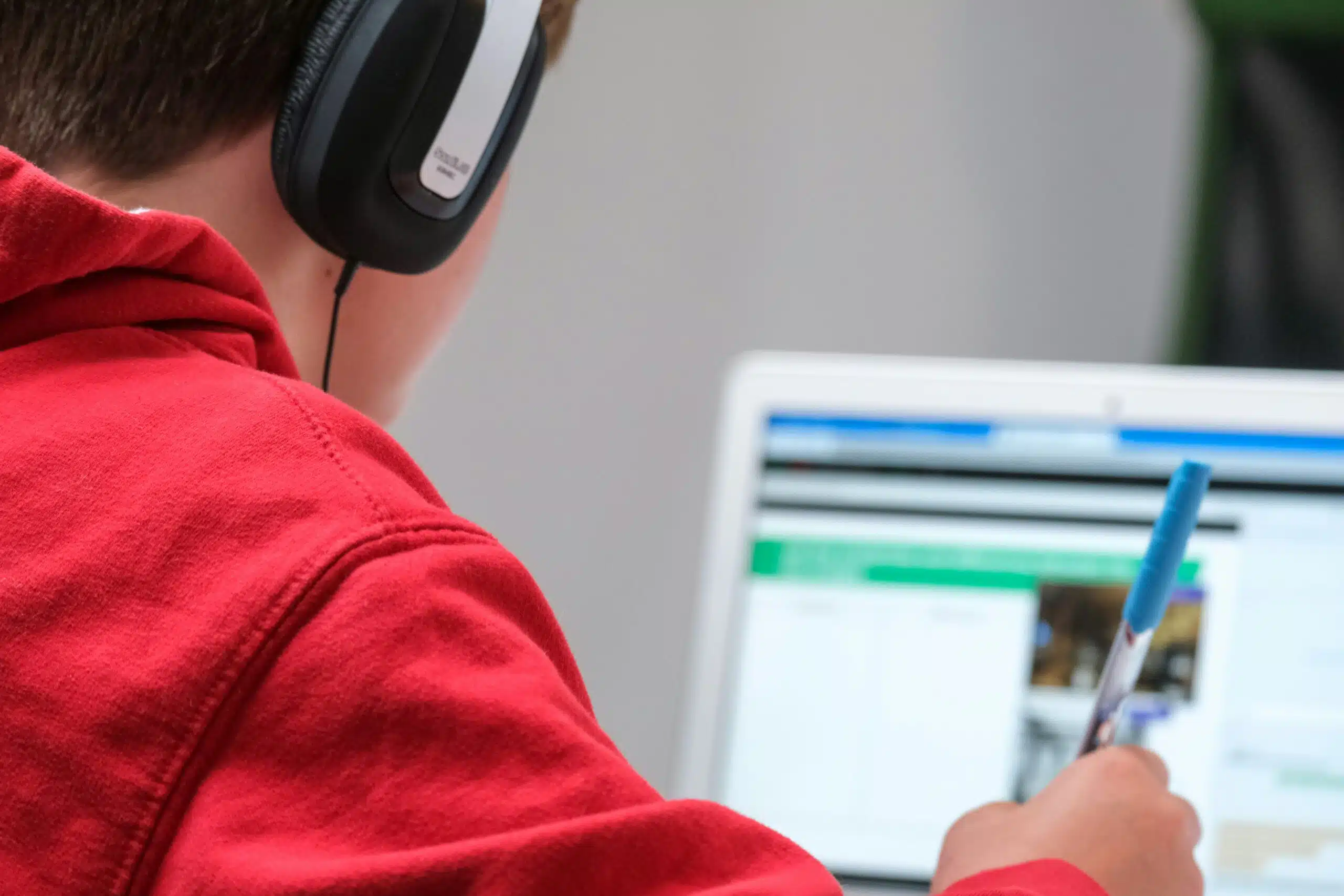 A person wearing headphones taking notes while working on an AI-powered advertising platform