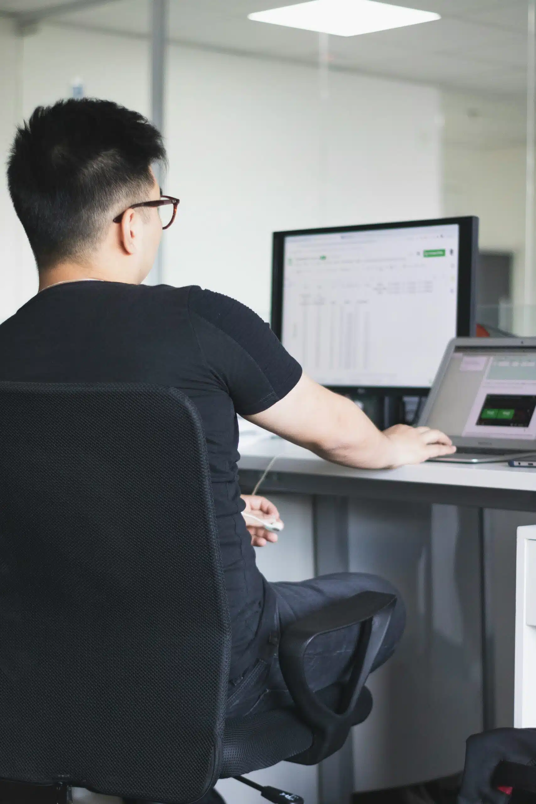 Man focused on a spreadsheet displayed on a computer screen