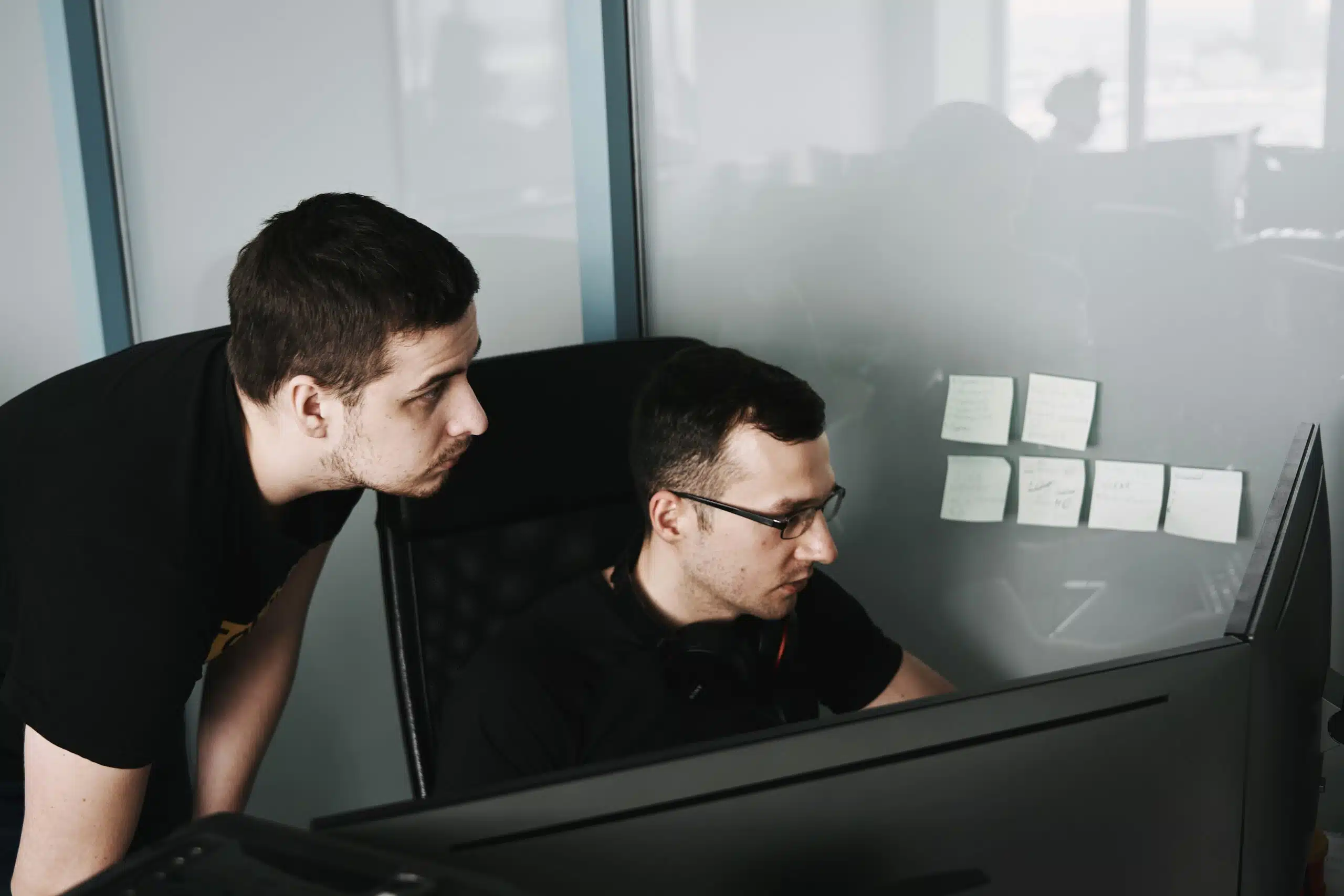 Developers collaborating on AI sales forecasting software in an office