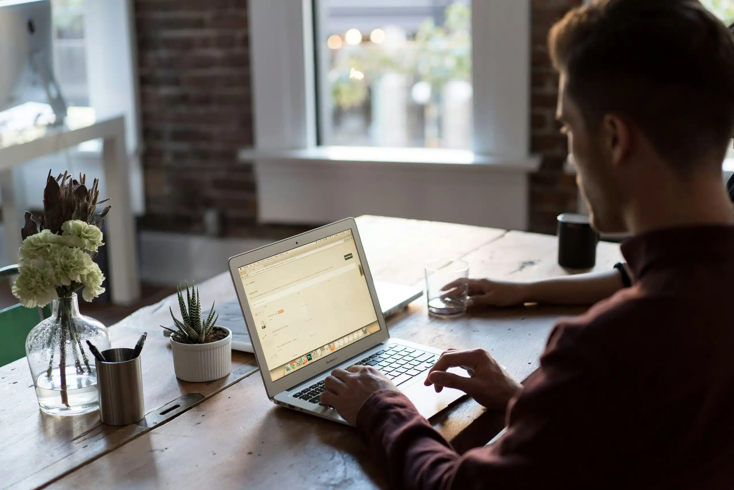 Professional working on a laptop with data dashboards in a cozy office with natural light.