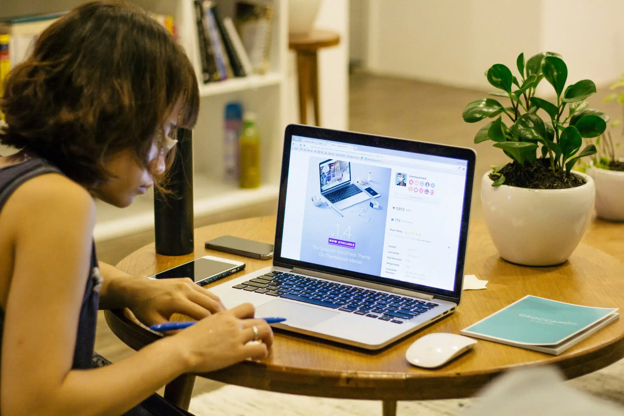 woman taking down notes with her laptop open on a desk