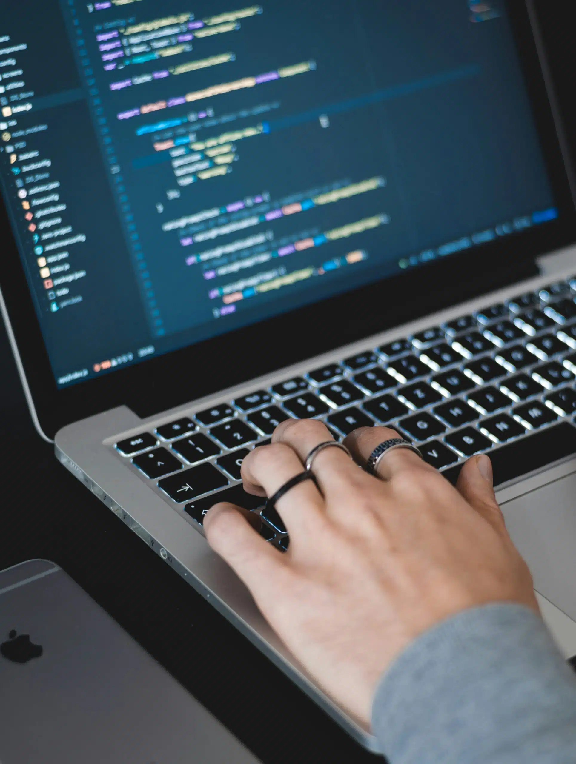 closeup of handing typing in a code on laptop
