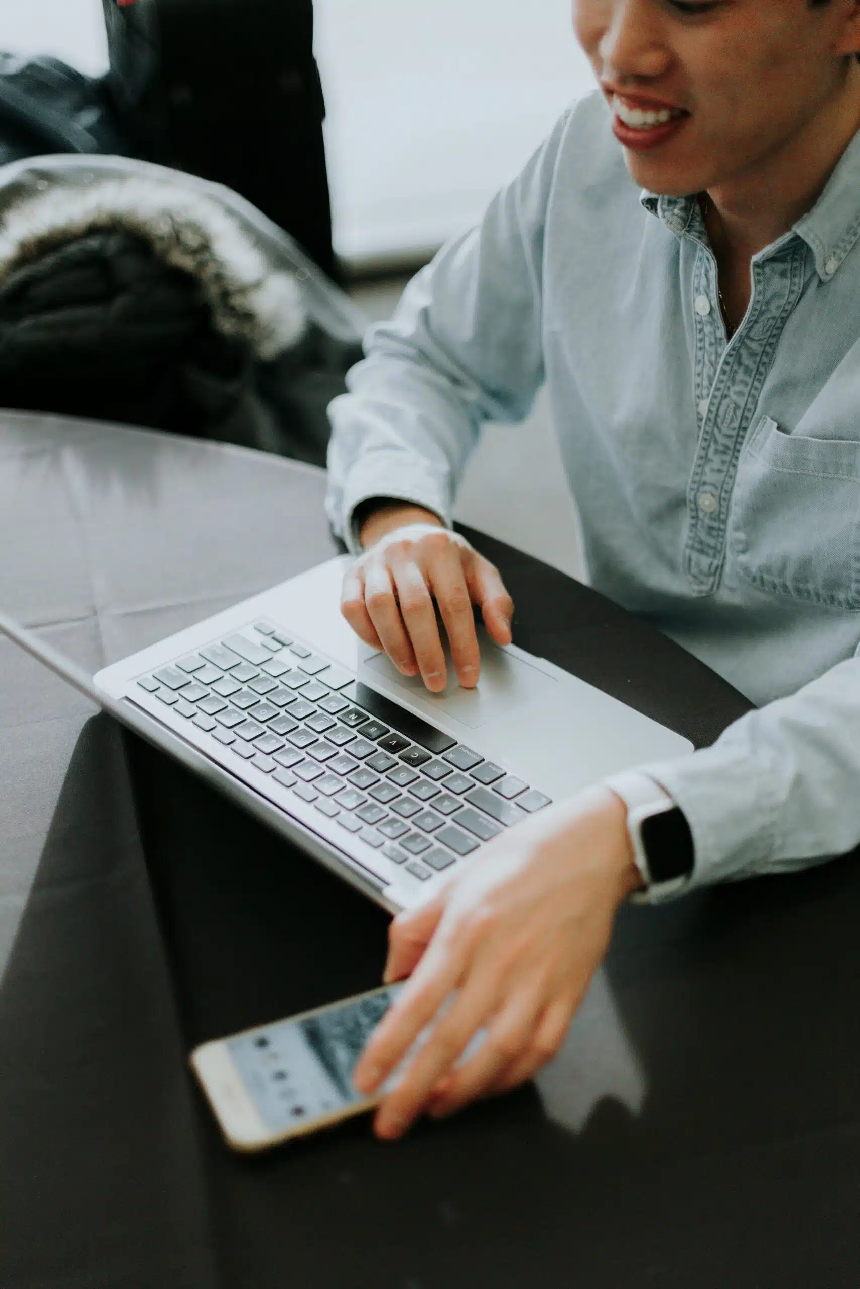 a man with laptop smiling