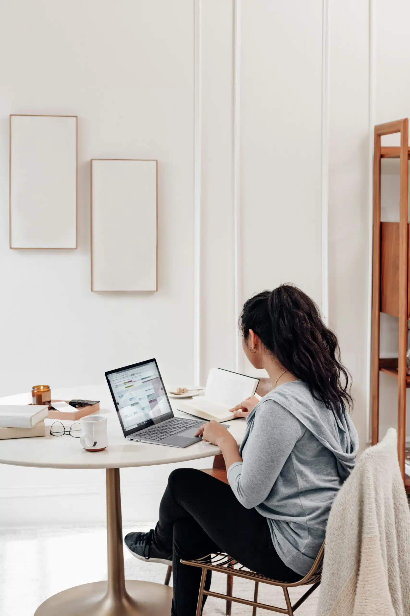 a woman in a home office space working on a laptop
