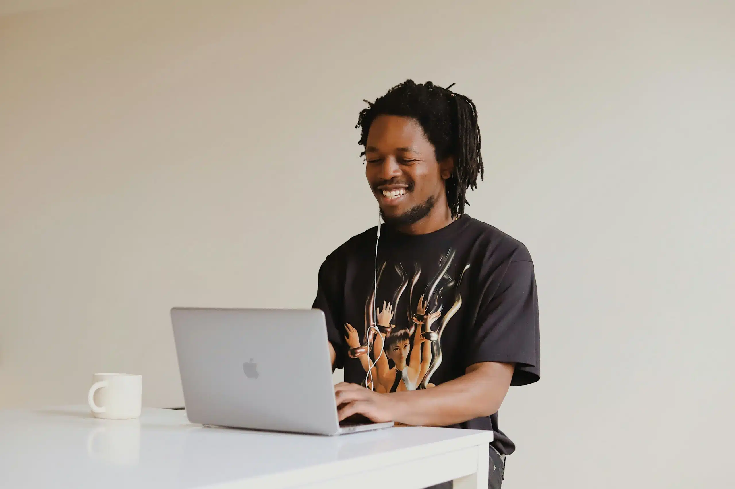 a man working on laptop with wired headphones plugged in