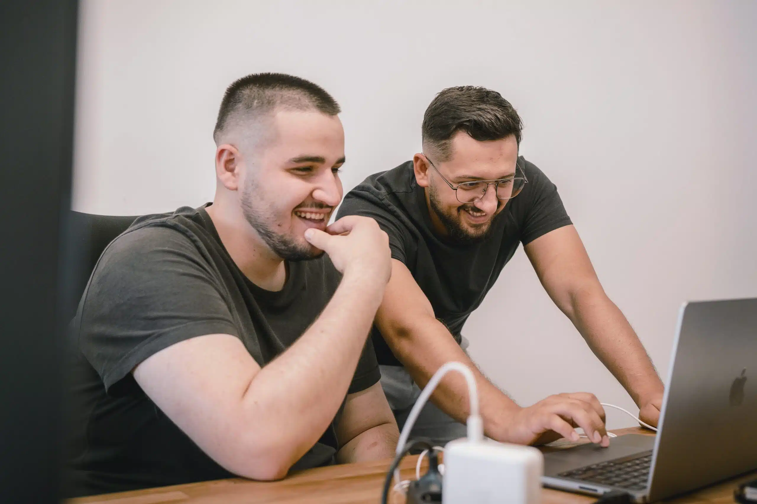 two guys analyzing ai challenges on a laptop