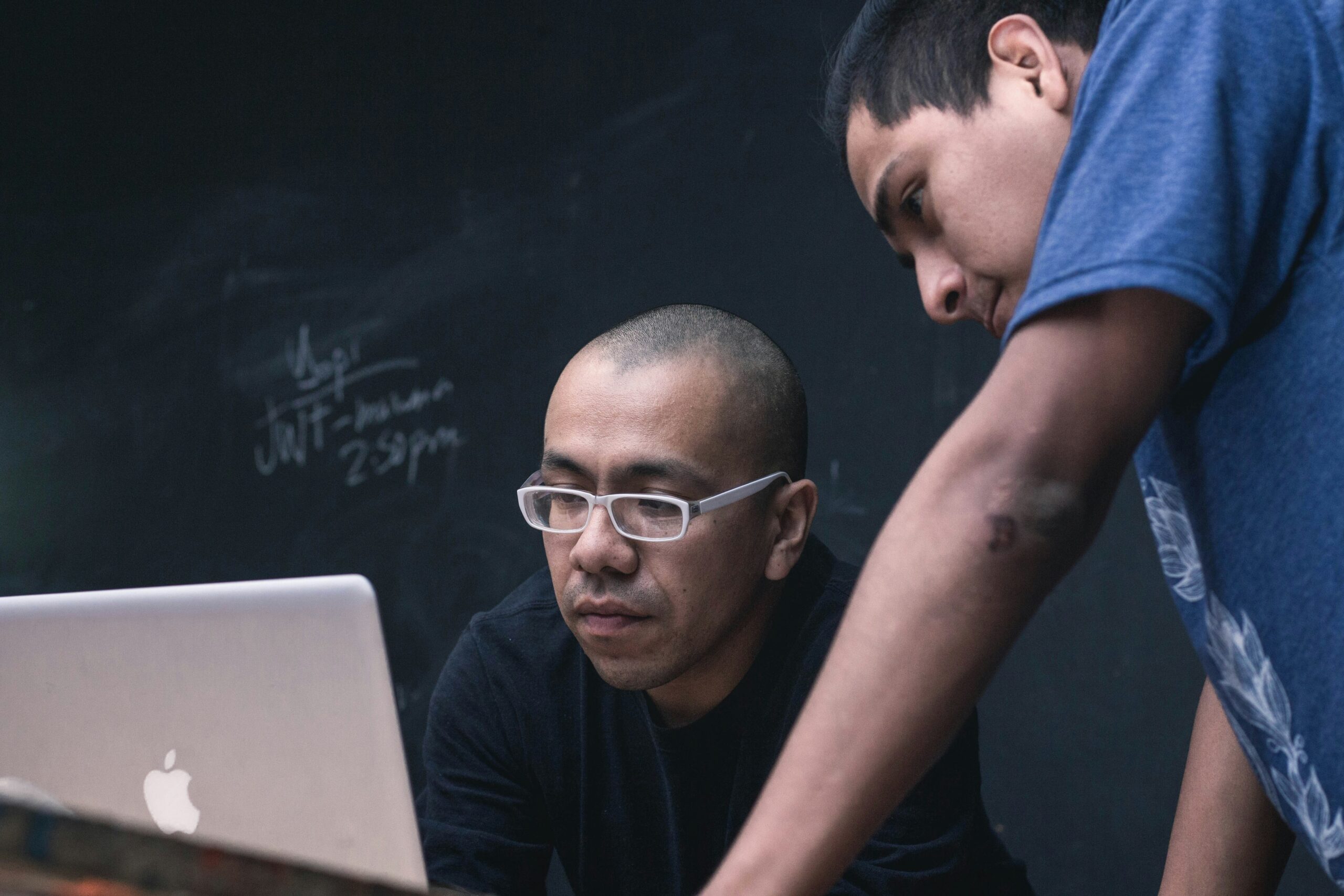 Two men reviewing predictive sales models on a laptop screen - AI Marketing Tools Two men reviewing predictive sales models on a laptop screen