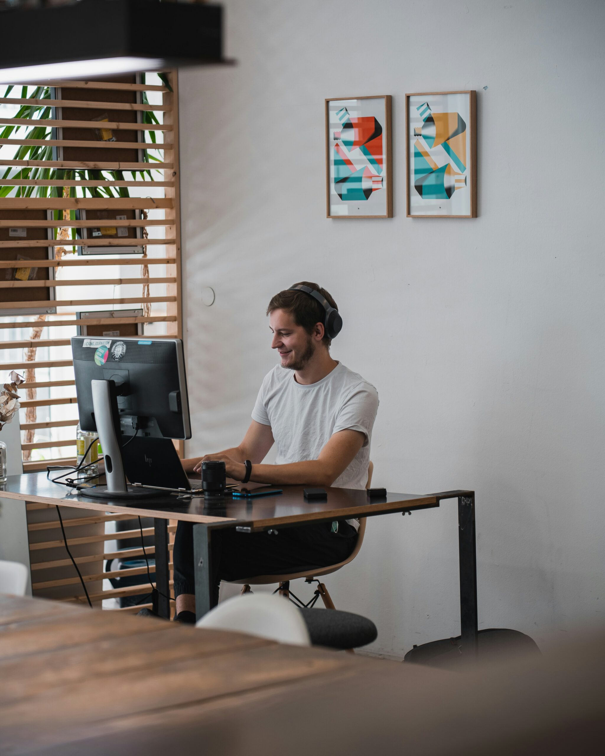 A man wearing headphones working at a computer in a modern workspace, symbolizing the evolving role of AI chatbots in future lead generation workflows.
