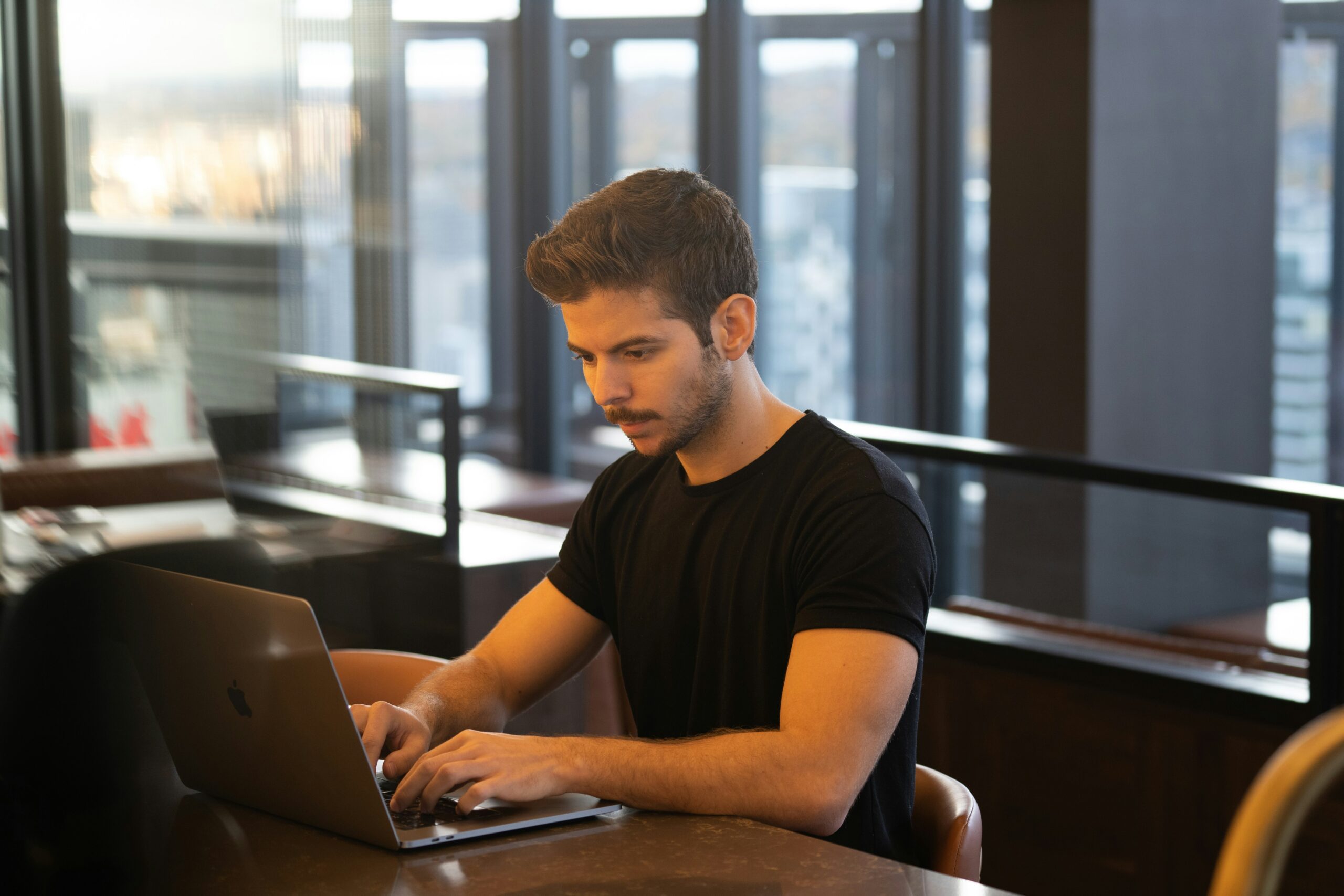 Man working on sales forecasting with AI tools in a modern office - AI Marketing Tools Man working on sales forecasting with AI tools in a modern office
