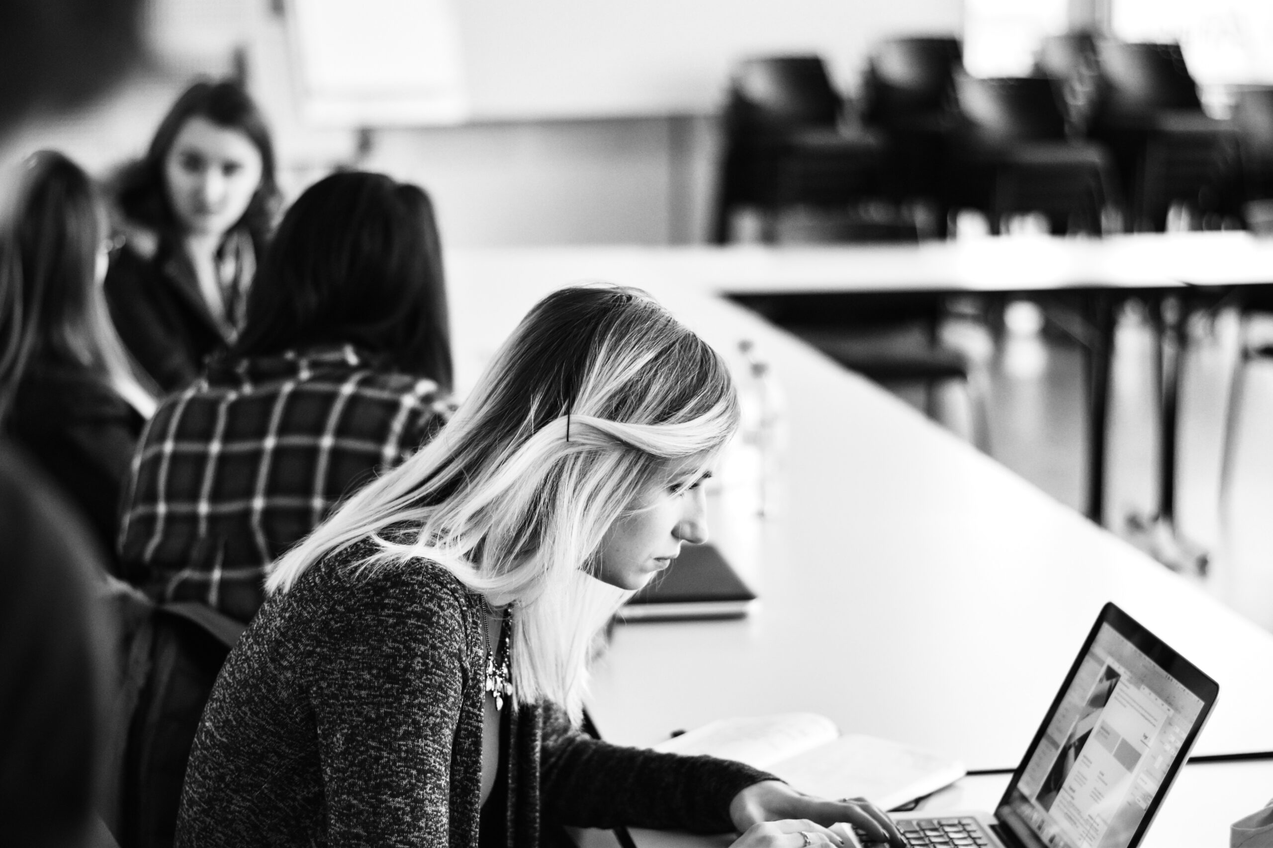 Woman analyzing advertising data on laptop in a group workshop - AI Marketing Tools Woman analyzing advertising data on laptop in a group workshop