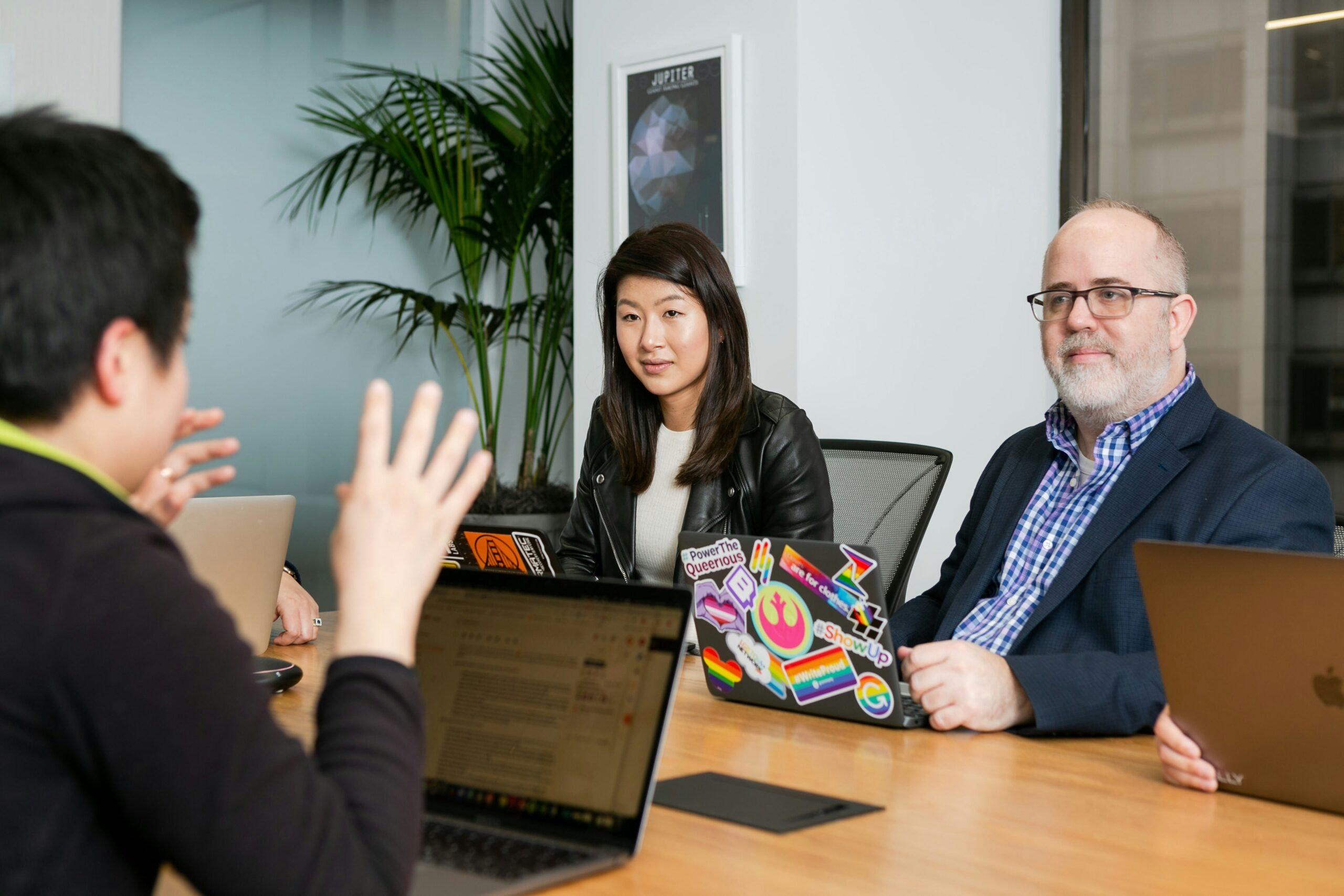 Marketing team discussing data strategies around a conference table with laptops